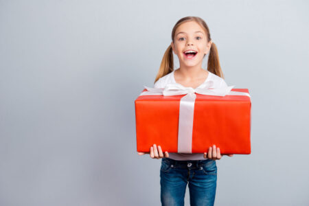 Young girl holding big wrapped gift