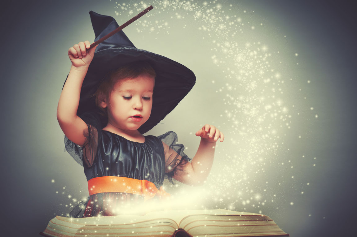 little girl in a witch costume casting a spell for Halloween