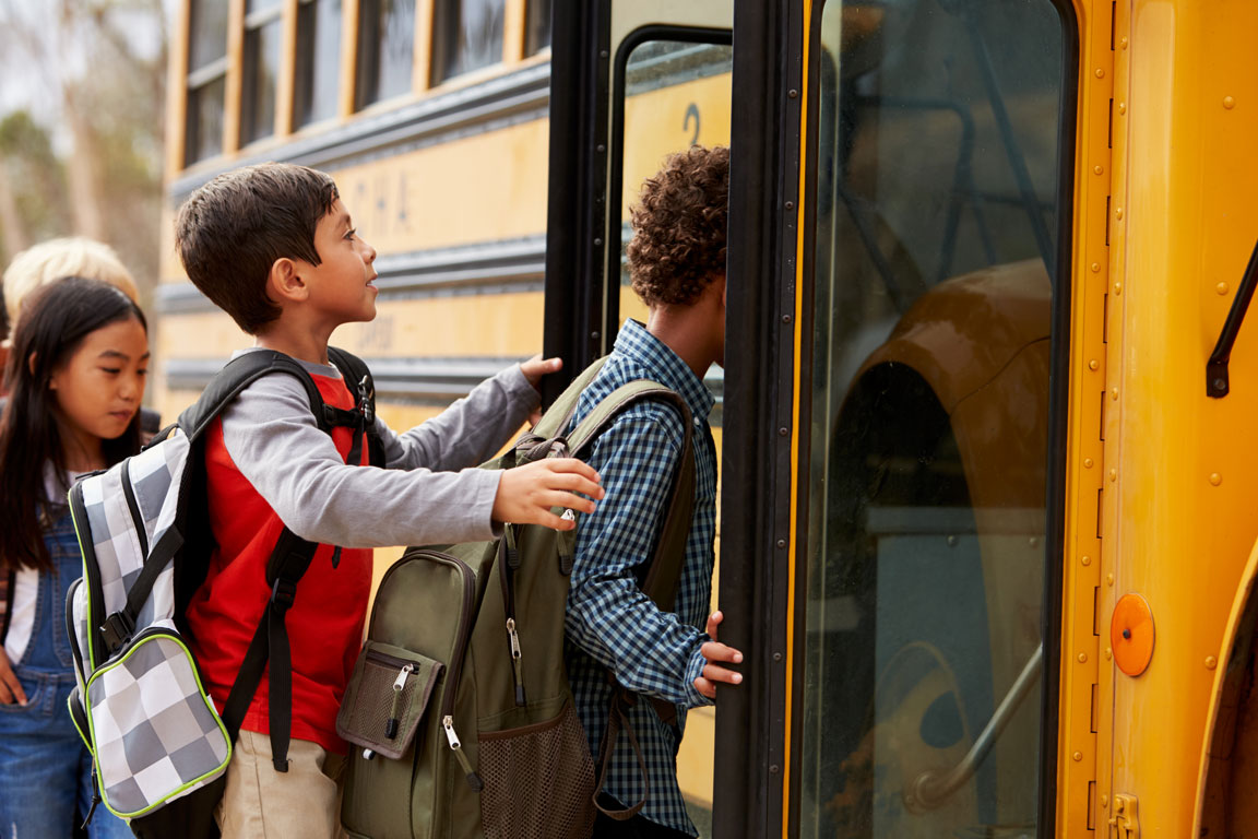elementary school kids climbing onto school bus